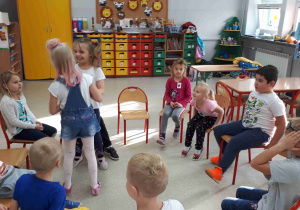 Dzieci siedzą w kole na krzesełkach - zamieniają się miejscami na podane hasło